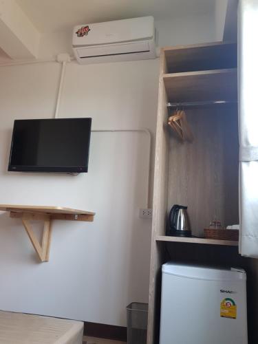 a refrigerator with a flat screen tv on the wall at SLEEP TO FLY HOTEL & HOSTEL suvarnabhumi airport in Bangkok