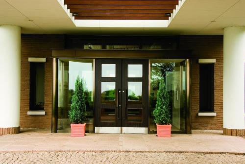 a building with two potted plants in front of a door at Hotel Village Izukogen in Ito