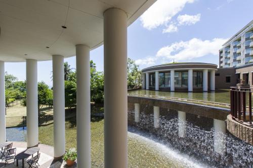 a view of the front of a building with a fountain at Hotel Village Izukogen in Ito