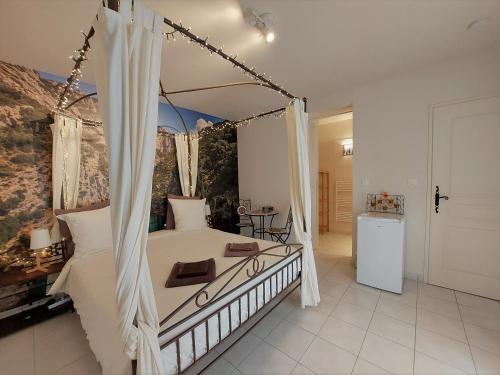 um quarto com uma cama de dossel branca em Rêve du VerDHon em Régusse
