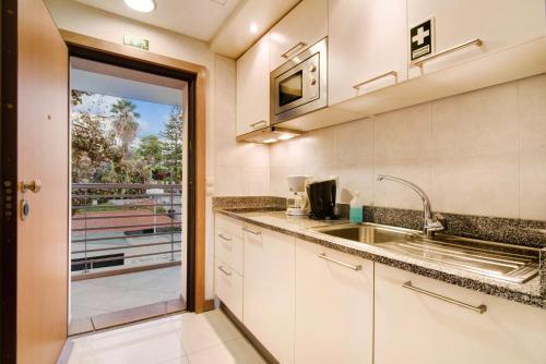 a kitchen with a sink and a sliding glass door at Dfm Happy Days D - Funchal in Funchal