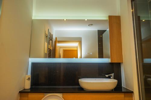 a bathroom with a sink and a mirror at DARTFORD LUXURY 2 BED APARTMENT in Kent