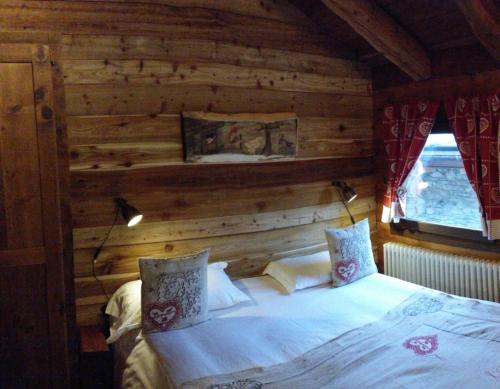 a bedroom with a bed in a wooden wall at BAITA Ancienne Bergerie in Valtournenche