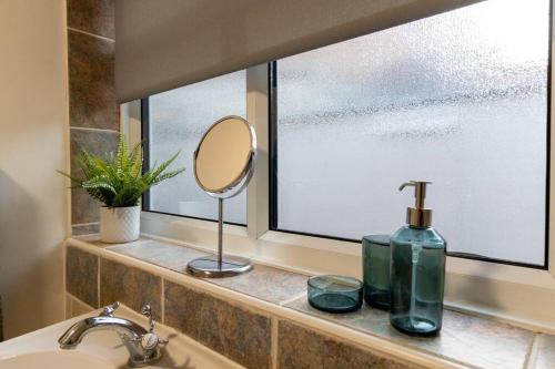 a bathroom sink with a mirror and a window at Room for All Your 4-Bedroom Comfort Zone in Leicester