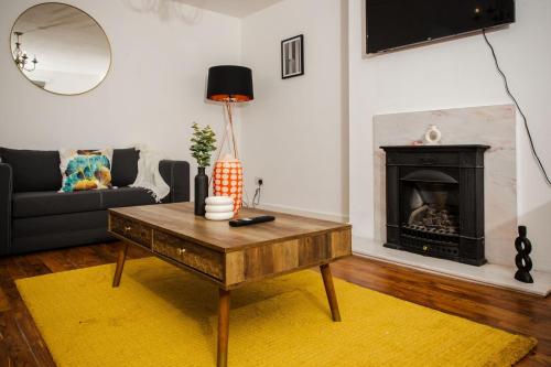 a living room with a coffee table and a fireplace at Tower Square House in Alloa