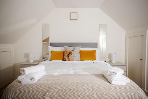 a bedroom with a large white bed with orange pillows at Tower Square House in Alloa