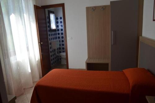 1 dormitorio con cama roja y baño en Albergo Diana en Tronzano Lago Maggiore