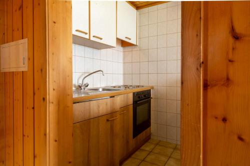 a kitchen with a sink and a stove at Chalet Weisshorn 4 in Bettmeralp