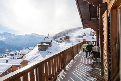 a balcony view of a town with snow covered roofs at Chalet Weisshorn 4 in Bettmeralp