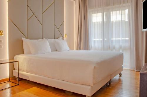 a large white bed in a room with a window at NH Collection Roma Giustiniano in Rome