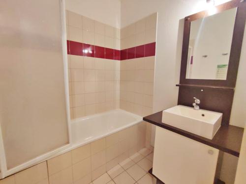 une salle de bain avec un lavabo et une baignoire dans l'établissement Ostal, T3, centre Luchon, wifi, casier à skis, ascenseur, 6 personnes, à Luchon