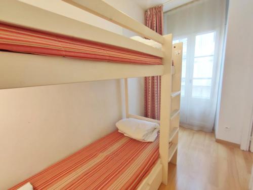 une chambre avec deux lits superposés et une fenêtre dans l'établissement Ostal, T3, centre Luchon, wifi, casier à skis, ascenseur, 6 personnes, à Luchon