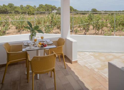 a dining room with a table and chairs and a view of a vineyard at Stella Maris - Formentera Break in Playa Migjorn