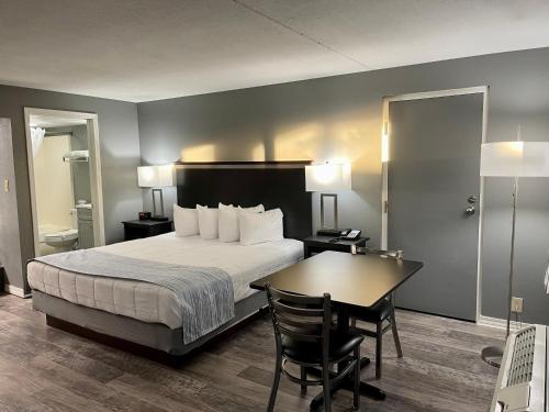 a hotel room with a bed and a desk and a table at Lake Norfork Resort in Henderson