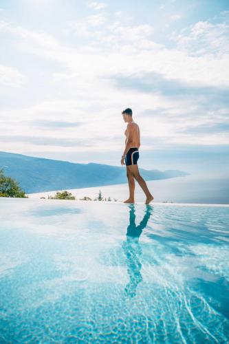 a man walking on the water in the ocean at BnB Borgo le Vigne - L'Uva rara Only Adults in Tignale