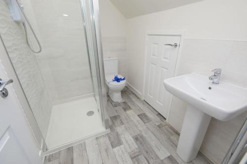 uma casa de banho com um WC, um lavatório e um chuveiro em Urban Bliss, Park with Ease 3 Bed New Build Home em Leicester