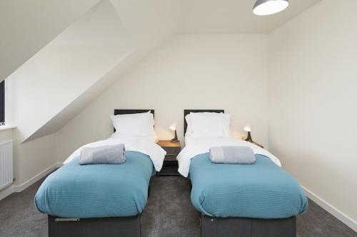 two beds in a room with a attic at Urban Bliss, Park with Ease 3 Bed New Build Home in Leicester