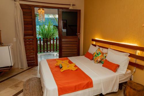 1 dormitorio con 1 cama con manta naranja en Camozen Resort & Spa, en Camocim