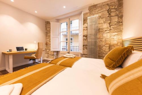 2 letti in camera d'albergo con scrivania di Bravissimo Ferreries, 3-bedroom apartment a Girona