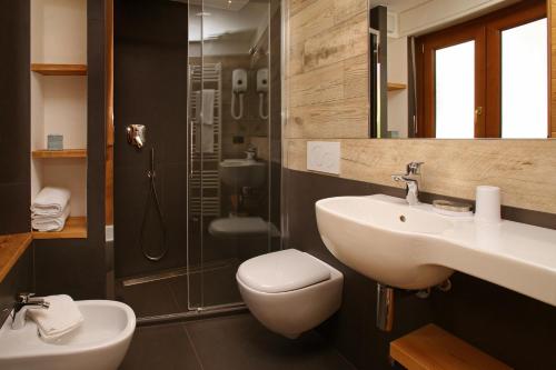 a bathroom with a sink and a toilet and a shower at Hotel Biancaneve in Sauze dʼOulx