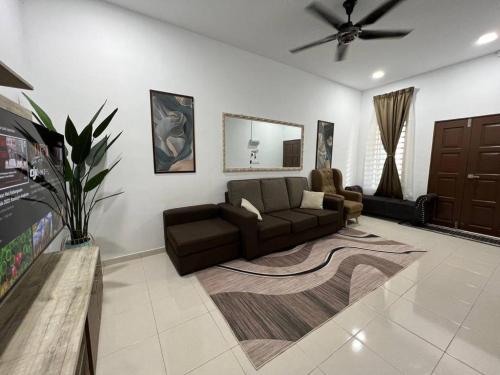 a living room with a couch and a ceiling fan at Homestay Kemaman Fyna06 in Kemaman