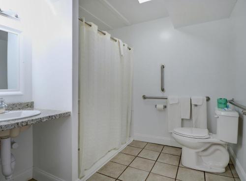 a white bathroom with a toilet and a sink at Classic Inn in Saco