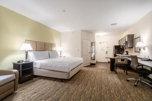 a large hotel room with a bed and a desk at Candlewood Suites Portland Airport by IHG in Portland