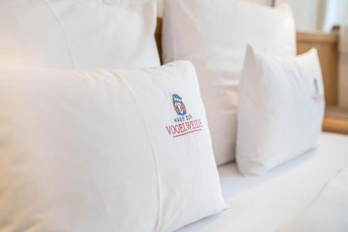 a bed with white pillows with a sign on it at Haus zur Vogelweide App 6 in Dobbiaco