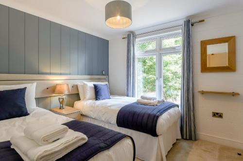a bedroom with two beds and a window at Woolverstone Marina and Lodge Park in Ipswich