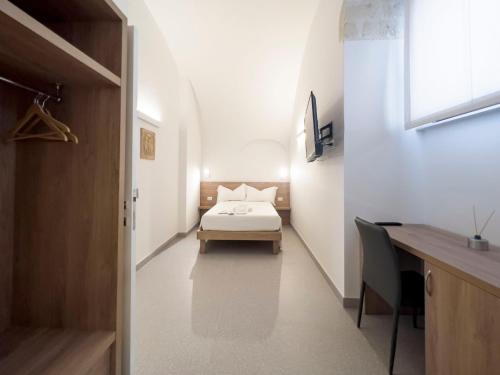 a bedroom with a bed and a desk and a bed sidx sidx sidx at Dimora dei Celestini in Manfredonia