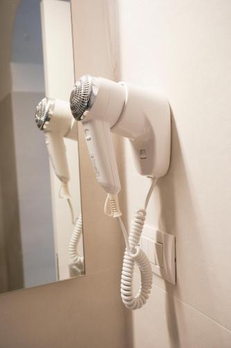 a white phone on a wall in front of a mirror at Dimora dei Celestini in Manfredonia