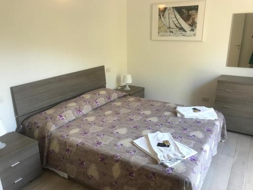 a bedroom with a bed with two towels on it at Appartamento Rosa Residenza Prealba in Levanto