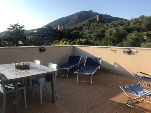 a balcony with a table and chairs and a mountain at Appartamento Rosa Residenza Prealba in Levanto