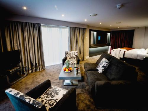 um quarto de hotel com um sofá e uma cama em Claregalway Hotel em Claregalway