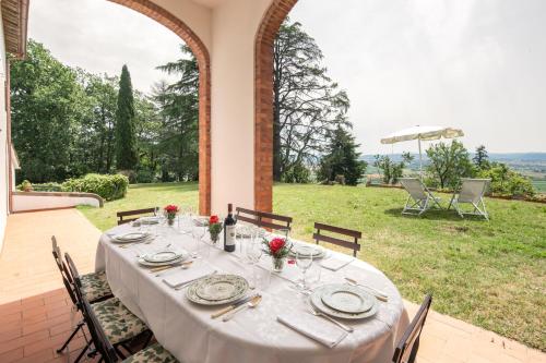 a table with a white table cloth on a patio at Exclusive 1970s villa with pool and garden by VacaVilla in Montefalcone