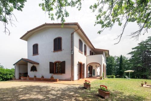 a large white house with a yard at Exclusive 1970s villa with pool and garden by VacaVilla in Montefalcone