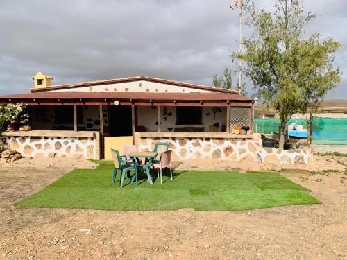 a house with a table and chairs on a patch of grass at Casa Rural Tindaya in Tindaya