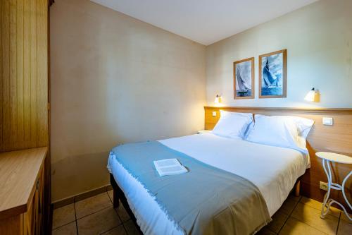 - une chambre avec un grand lit et une table dans l'établissement Résidence Pierre & Vacances Les Dunes du Médoc, à Soulac-sur-Mer