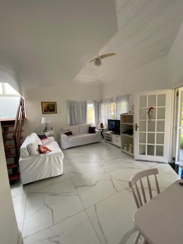 Casa com 4 quartos e 3 suítes no condomínio ferradura. في بوزيوس: غرفة معيشة مع أرضية بلاط بيضاء كبيرة