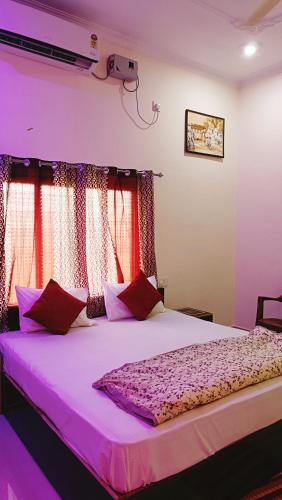 a bedroom with a large bed with red curtains at The Mountain View Home Stay in Khajurāho