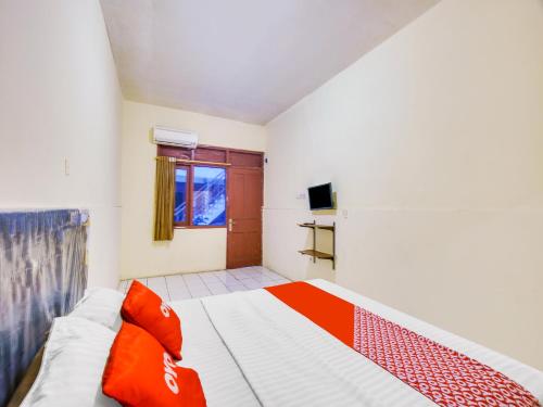 una camera da letto con un letto con cuscini rossi di SUPER OYO 591 Mn Residence Syariah a Giacarta