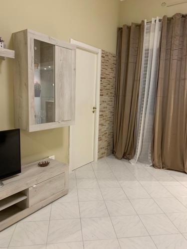 a living room with a television and a tiled floor at Casa Leila in Palermo