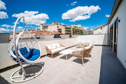 uma varanda com um baloiço, uma mesa e cadeiras em Smartr Madrid Gran Via Apartments em Madrid
