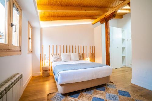 Schlafzimmer mit einem Bett mit Holzdecke in der Unterkunft Smartr Madrid Gran Via Apartments in Madrid