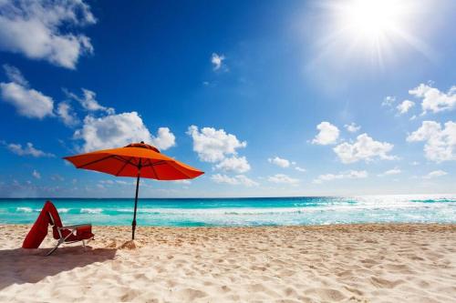 a chair and an umbrella on a beach at 3 Cottage Exclusive Retreat-Hot Tubs-Walk to Beach in Traverse City