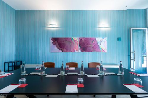 a conference room with a long table and chairs at Ramada Plaza by Wyndham Milano in Milan