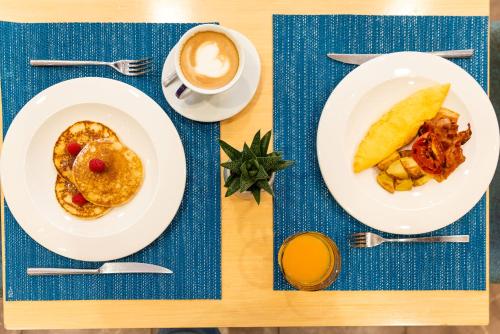 a table with plates of food and a cup of coffee at Ramada Plaza by Wyndham Milano in Milan
