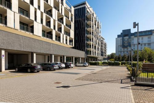 a parking lot with cars parked in front of a building at Ramada Plaza by Wyndham Milano in Milan