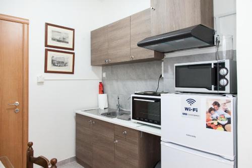 a kitchen with a microwave and a refrigerator at Cozy apartment near Stavros Niarchos Park in Athens