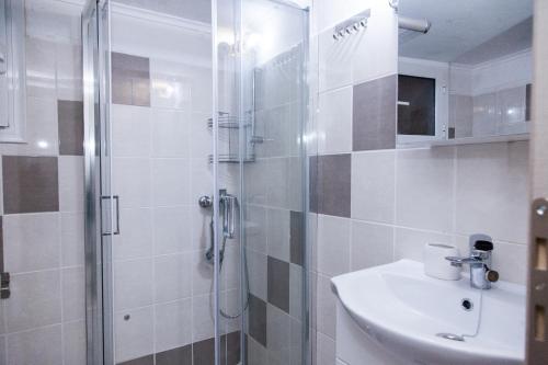 a bathroom with a sink and a shower at Cozy apartment near Stavros Niarchos Park in Athens